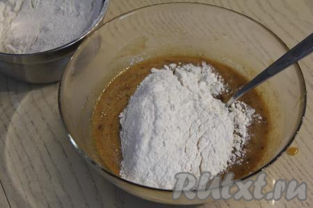 Массу остудить в течение 10 минут, а затем всыпать муку в несколько приёмов, каждый раз перемешивая тесто столовой ложкой до однородности.