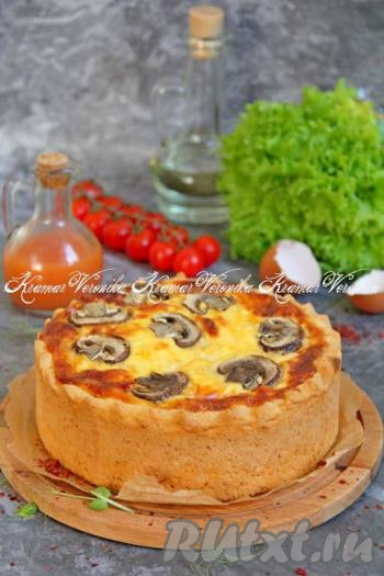 Готовый киш слегка остудить и снять бортики формы. Нарезать пирог на кусочки и подать к столу.