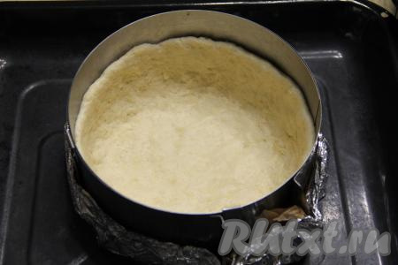 В форму для выпечки (лучше взять разъёмную форму) выложить тесто, формируя высокий бортик, и поставить в холодильник минут на 30. В качестве формы для выпечки я использовала разъёмное кулинарное кольцо диаметром 22 сантиметра, предварительно сформировав дно формы из фольги, сложенной в два слоя.