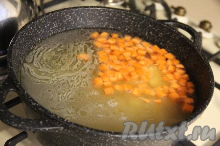 В кастрюлю с закипевшим куриным бульоном выложить кусочки куриного мяса, картошку и морковь, дать закипеть и варить на небольшом огне 15 минут (до мягкости овощей).