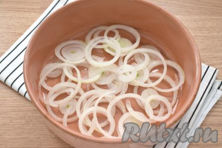 Очищаем репчатый лук и нарезаем его на тонкие колечки. Форму для запекания смазываем растительным маслом, выкладываем колечки лука.