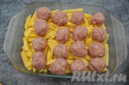 Из мясного фарша сформировать фрикадельки размером чуть больше, чем грецкий орех. Выложить фрикадельки в форму поверх картошки.