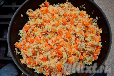 Всыпать сахар и небольшую щепотку соли, перемешать, дождаться, когда вода закипит, сделать огонь минимальным, накрыть сковороду крышкой. Готовить сладкий плов с изюмом и курагой 25 минут (рисинки должны стать мягкими, но не разваренными, вся вода должна испариться из сковороды).