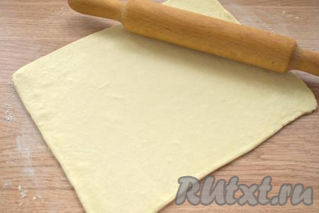 На стол, присыпанный мукой, выкладываем вначале один пласт размороженного слоёного теста. Раскатываем пласт теста до толщины примерно 3 миллиметра.