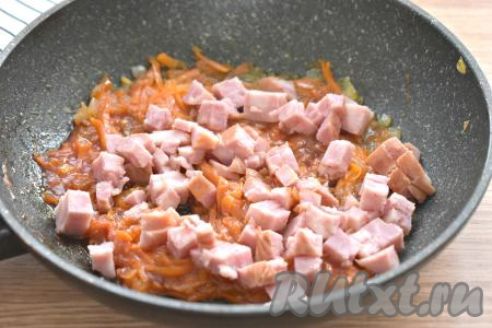 Колбасу нарезаем на кубики (или соломкой), выкладываем в сковороду с овощами, перемешиваем, обжариваем 2-3 минуты.