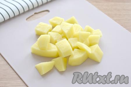 В кастрюле доводим до кипения 1,5 литра воды, затем выкладываем очищенный картофель, нарезанный на средние кубики.