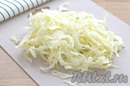 С капусты снимаем верхние листья. Затем нарезаем капусту на тонкие полоски и отправляем в кастрюлю сразу после добавления картофеля. Даём воде с овощами закипеть и варим на небольшом огне минут 20-25.