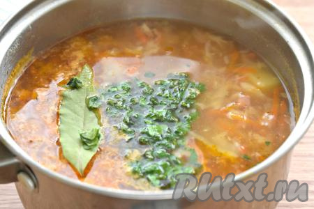 Затем в щи с колбасой добавляем нарезанную зелень, специи (у меня - универсальная приправа), лавровый лист и соль, даём закипеть и на небольшом огне провариваем 2-3 минуты, выключаем огонь. Даём щам настояться под крышкой 5-10 минут.