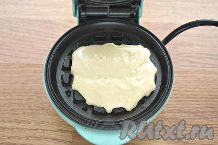 Панели электровафельницы смазываем растительным маслом и разогреваем согласно инструкции. В центр нижней панели выкладываем 1,5-2 столовых ложки получившегося теста.