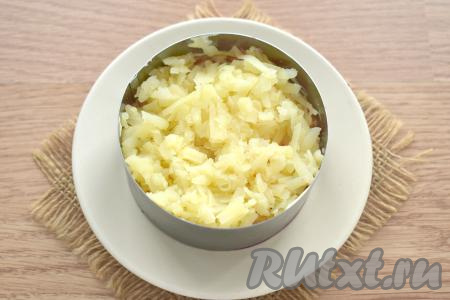 Затем выкладываем картофель, натёртый на крупной тёрке, немного солим.