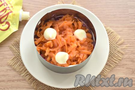 Следующим слоем равномерно раскладываем по двум кольцам морковь, натёртую на крупной тёрке, смазываем майонезом.