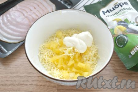 В салат из ананасов, чеснока и сыра добавляем майонез.