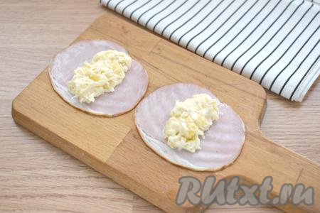 В центр каждого ломтика ветчины помещаем примерно 2 чайных ложки начинки из сыра и ананаса.