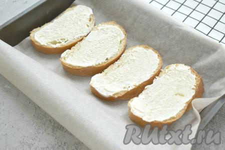 Форму для запекания (или противень) застилаем пекарской бумагой, выкладываем ломтики батона, смазываем их майонезом.