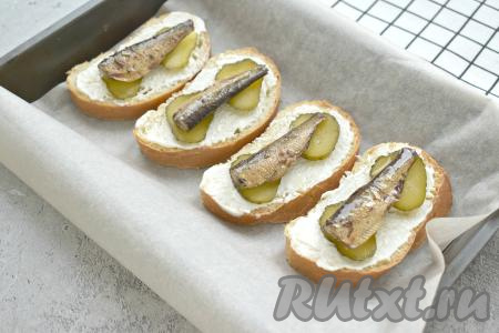 Поверх огурца выкладываем по 1 шпротинке.