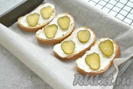 Солёный огурец нарезаем на тонкие кружочки. На каждый бутерброд выкладываем по 2 кружочка огурца.