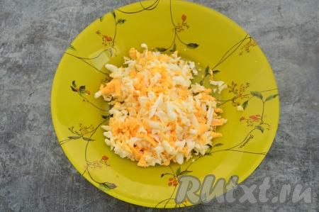Отварить яйца в течение 10 минут после закипания воды, а затем дать им остыть, очистить и натереть на крупной тёрке в глубокую тарелку.