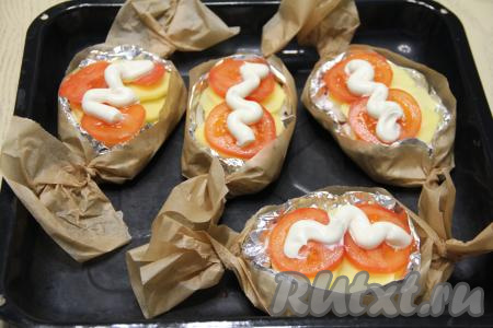 Закрутить концы фольги, а затем пергамента, сформировав форму с бортиками. Переложить формы с котлетами на противень. Поверх помидоров сделать полоску из майонеза (или сметаны). Из указанных в рецепте ингредиентов у меня получилось 4 порции котлет по-капитански.