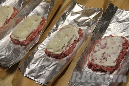 Смазать каждую котлету майонезом (или сметаной), сверху выложить лук, нарезанный полукольцами.