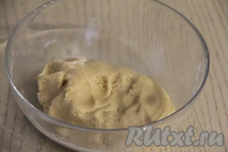 Постепенно добавляя оставшуюся муку, замесить очень мягкое и нежное тесто, собирая его в ком. Как только в процессе замешивания теста перемешивать вилкой станет сложно, продолжайте замешивать тесто руками. Очень важно ориентироваться на консистенцию теста для орешков, а не на количество муки. Долго вымешивать тесто не нужно, достаточно будет просто собрать его в ком.