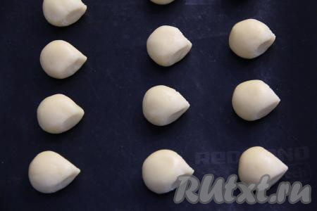 Поместить шарики в холодильник на 1 час. Затем каждый шарик переложить на противень, застеленный ковриком (или бумагой) для выпечки. Выкладывать шарики нужно на небольшом расстоянии друг от друга. Вытянуть пальцами один конец каждого шарика, как носик у ёжика.