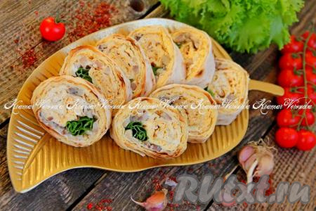 Затем развернуть фольгу, нарезать рулет на кусочки. Переложить аппетитные, вкусные рулетики из лаваша с селёдкой и яйцом на тарелку и подать к столу.