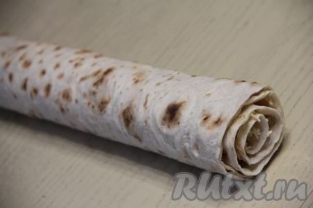 Завернуть лаваш с начинкой в плотный рулет, начиная со стороны с яйцом.