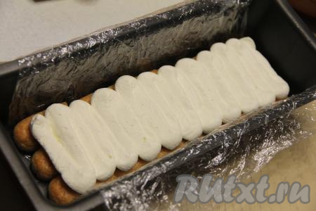 Отсадить треть крема из кондитерского мешка на печенье (можно выложить ложкой).