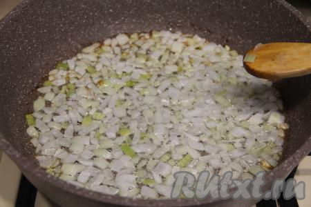 В сковороду влить растительное масло, дать ему прогреться и выложить нарезанный лук, обжарить его, периодически помешивая, до прозрачности (в течение 3-4 минут) на среднем огне.