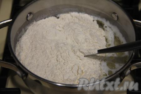 В кипящую смесь молока и растительного масла всыпать всю муку.&nbsp;
