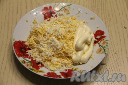 В отдельную глубокую тарелку натереть на мелкой тёрке яйца, добавить 3 столовых ложки майонеза, перемешать.