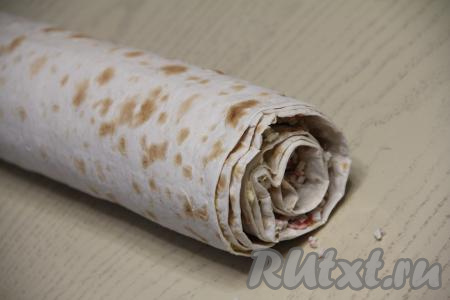 Свернуть 3 листа лаваша с начинкой в плотный рулет, начиная с короткого края.