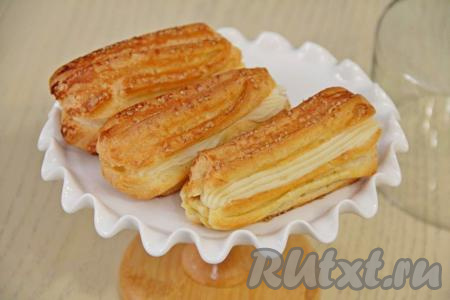 Остывшие эклеры наполнить заварным кремом. Я разрезала эклеры с боку и отсадила крем через кулинарный мешок.