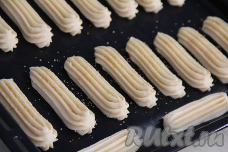 Я часть эклеров присыпала тростниковым сахаром. Поставить противень с эклерами в разогретую до 220 градусов духовку. Выпекать минут 15, затем, не открывая духовку, убавить огонь до 200 градусов и выпекать ещё минут 15.