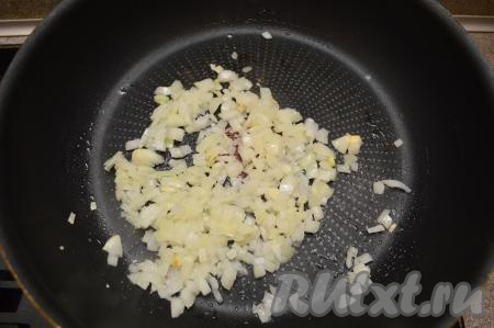 Морковку и лук очистить. Нарезать лук на небольшие кубики и выложить в хорошо разогретую с растительным маслом сковороду. Жарить лук минуты 2 (до прозрачности) на среднем огне, иногда помешивая.