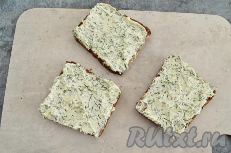 Обильно намазать на каждый кусок чёрного хлеба смесь из творожного сыра, чеснока и укропа.