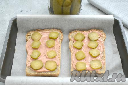 Солёный (или маринованный) огурчик нарезаем на тонкие кружочки и выкладываем на смазанные ломтики хлеба.