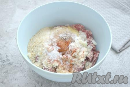 К фаршу с луком всыпаем панировочные сухари, добавляем яйцо, солим, приправляем молотыми специями.