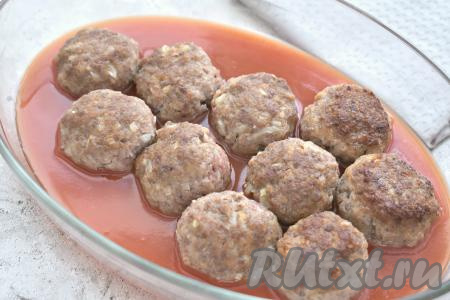 Обжаренные заготовки тефтелей перекладываем в форму для запекания. В небольшой ёмкости томатную пасту разводим 250 миллилитрами тёплой кипячёной воды. Затем получившимся томатным соусом заливаем тефтели (соус должен доходить до средины тефтелей) и отправляем в духовку, прогретую предварительно до 200 градусов.