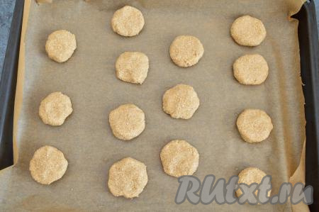 Противень застелить пергаментом. Влажными руками сформировать из овсяного теста круглые шарики размером чуть больше, чем грецкий орех (у меня получилось 14 штук). Выложить шарики на противень на приличном расстоянии друг от друга. Прижать каждый шарик немного руками, чтобы получился толстенький кружок.