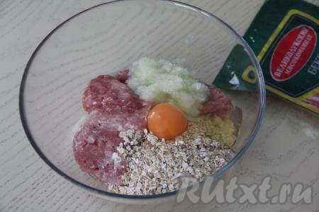 Переложить фарш в объёмную миску, сюда же выложить пропущенные через мясорубку лук и чеснок, всыпать овсяные хлопья (я взяла хлопья № 2 - среднего размера), добавить сырое яйцо.