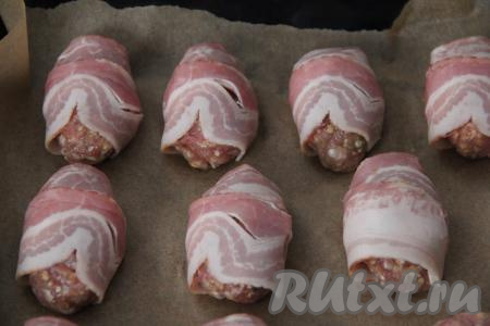 Выложить котлеты в беконе на противень, застеленный пергаментом, и отправить в хорошо прогревшуюся духовку.