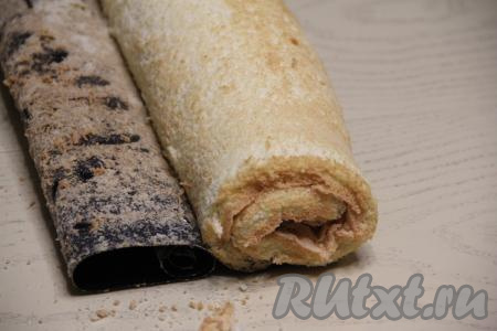 Свернуть бисквит с начинкой из творога и мака в плотный рулет, начиная с узкой стороны.