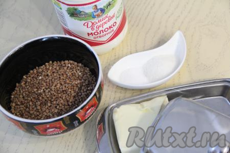 Подготовить продукты для приготовления гречневой каши на молоке в мультиварке Редмонд. Гречку, если необходимо, перебрать, убирая некачественные зёрнышки, затем переложить в сито и хорошо промыть её под проточной водой, после этого дать стечь лишней воде с крупы.