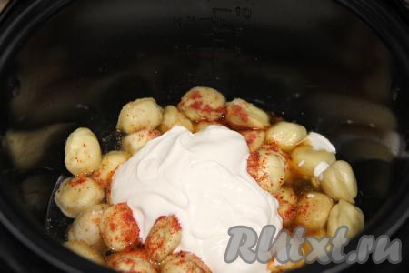 Добавить в чашу сметану и 150 миллилитров воды комнатной температуры, перемешать пельмени, закрыть крышку мультиварки и выставить режим "Тушение" на 15 минут.