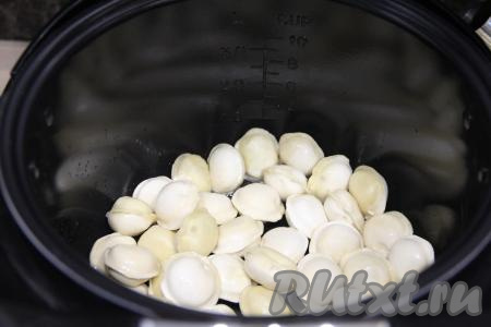 Растительное масло влить в чашу мультиварки, выставить режим "Жарка". Выложить замороженные пельмени в чашу мультиварки и обжаривать их 15 минут (до лёгкого золотистого цвета), периодически перемешивая.