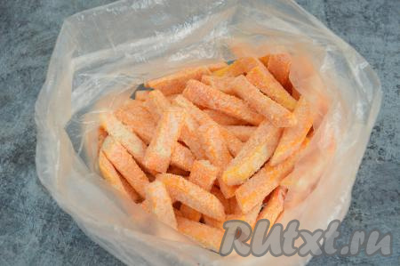 Развязать пакет, влить 2 столовых ложки растительного масла. Снова завязать пакет и ещё раз потрясти, чтобы масло равномерно распределилось по тыкве.