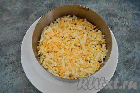Яйца очистить, натереть на крупной тёрке и выложить следующим слоем салата, слегка подсолить, немного утрамбовать этот слой.
