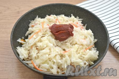 Квашеную капусту откидываем сначала на дуршлаг. Если капуста слишком кислая, промываем её под холодной водой, даём стечь лишней жидкости. После того как жареная морковь станет достаточно мягкой, добавляем в сковороду квашеную капусту и томатную пасту, перемешиваем.