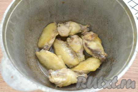 Разогреваем в казане (или в глубокой сковороде) растительное масло, затем выкладываем крылышки и обжариваем их 7-10 минут (до подрумянивания с двух сторон), периодически переворачивая, на среднем огне.